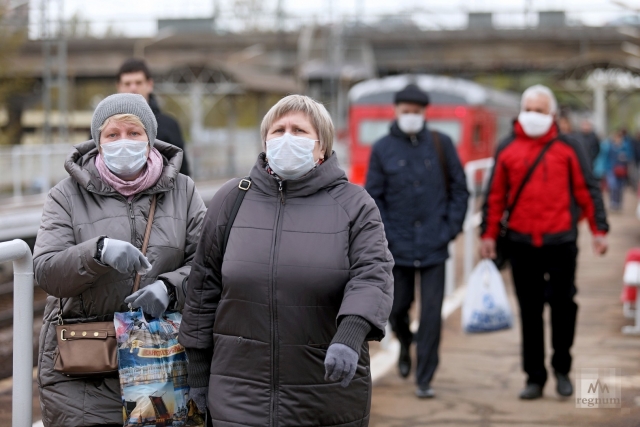Пассажиры в масках выходят из электрички в Петербурге 