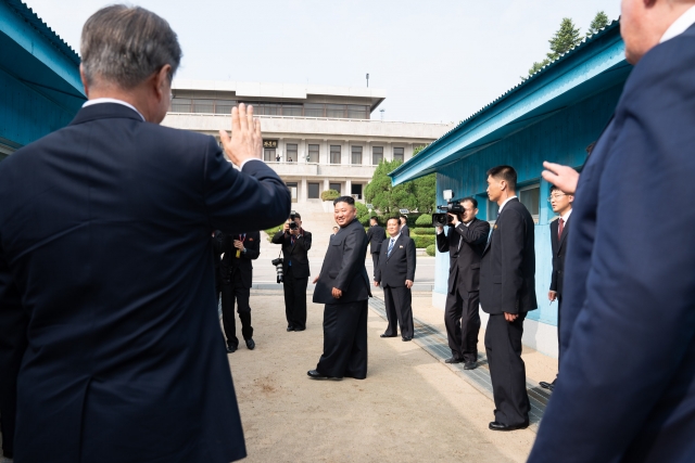 Дональд Трамп и Мун Чжэ Ин прощаются с Ким Чен Ыном на демаркационной линии, разделяющей Северную и Южную Корею, 30 июня 2019 года