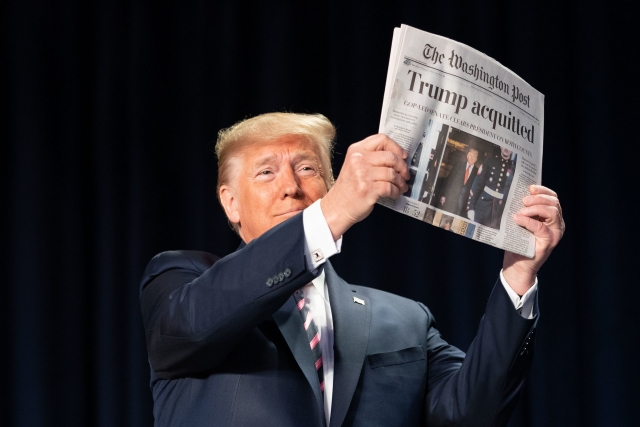 Дональд Трамп показывает газету The Washington Post с заголовком «Трамп оправдан»