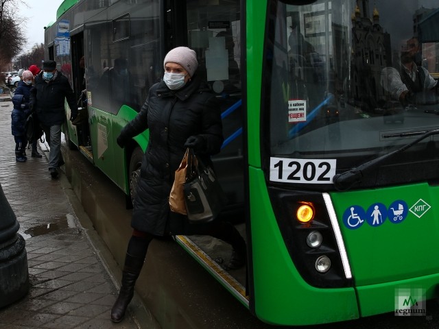 Женщина в маске выходит из автобуса