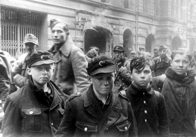 Колонна пленных на улице Берлина. На переднем плане «последняя надежда Германии» — мальчишки из гитлерюгенда и фольксштурма