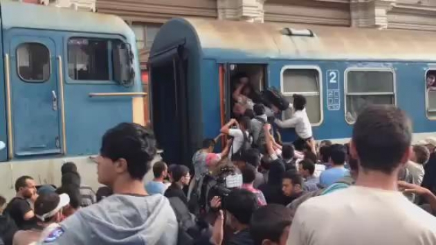 Мигранты штурмуют поезд на вокзале Будапешта.