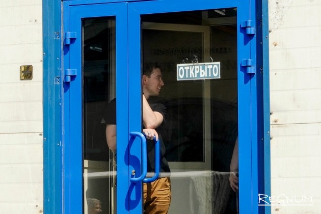 Сотрудники ТЦ «Электрон» закрывают двери, чтобы не допустить сотрудников инспекции внутрь здания
