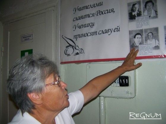 Директор Кучукской средней школы Валентина Кутькова показывает стенд, посвященный учителям, работавшим в школе. День знаний