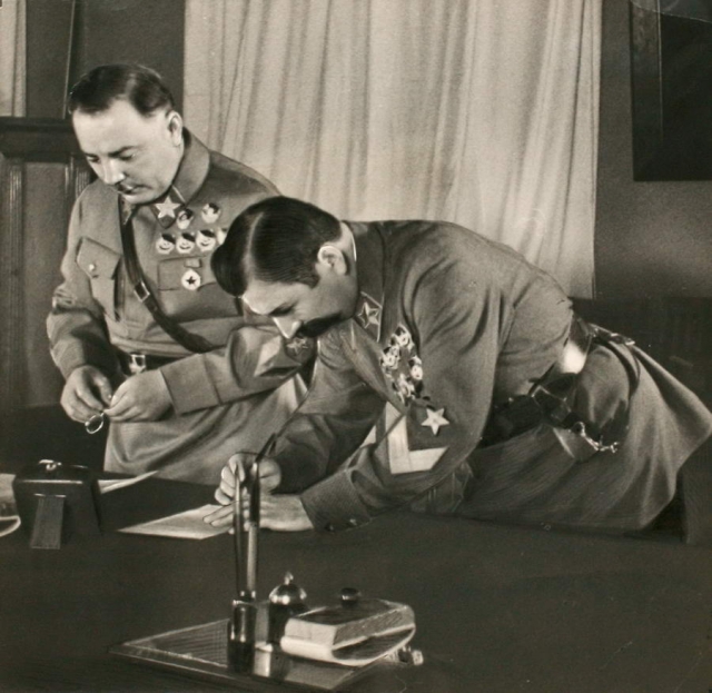 Маршал Советского Союза Семён Михайлович Будённый подписывает текст военной присяги