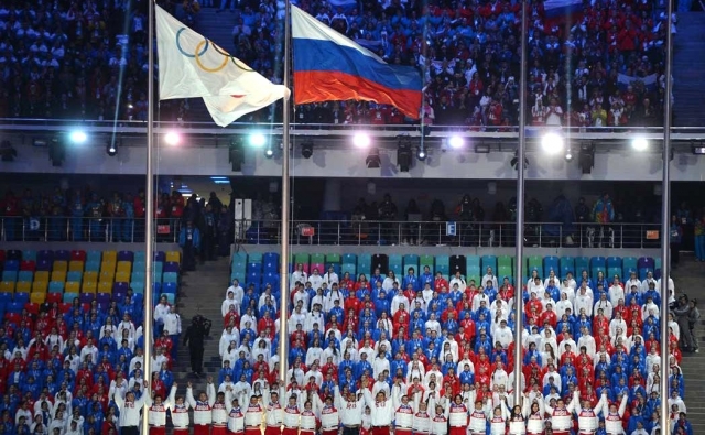 Олимпийский и российский флаги на церемонии закрытия Олимпийских игр 2014