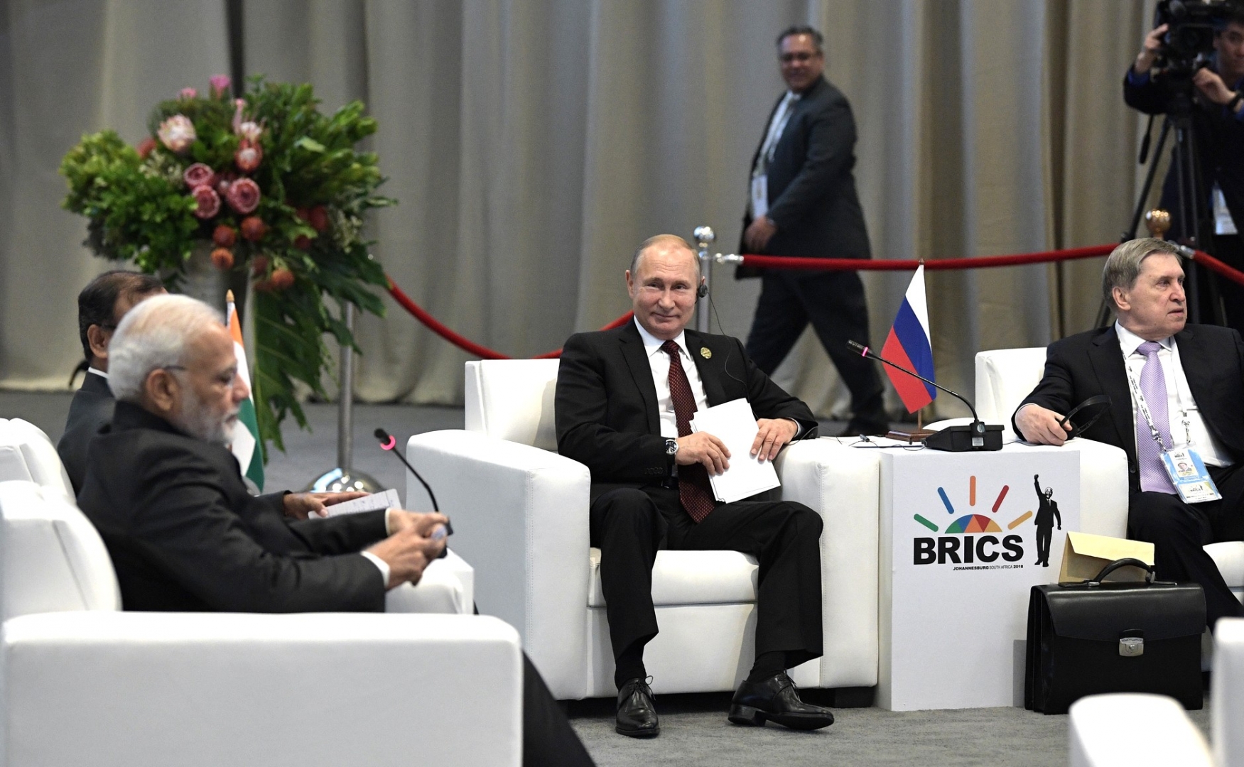 Владимир Путин с Нарендрой Моди (слева) и Юрием Ушаковым на встрече лидеров БРИКС по вопросам развития БРИКС и приоритетов стратегического партнёрства. 27 июля 2018 года, Йоханнесбург