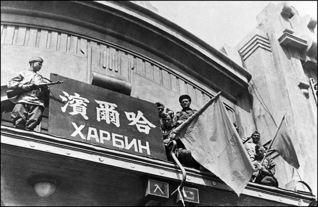 Советские бойцы водружают флаг над зданием вокзала. Харбин 1945 г