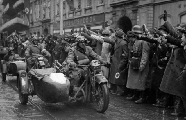 Жители чешской столицы Праги приветствуют колонну немецких мотоциклистов