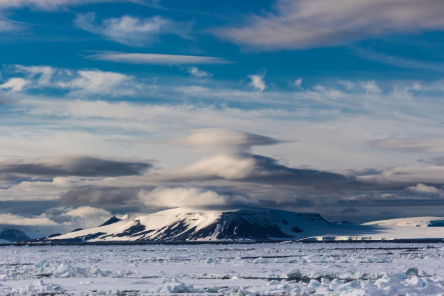 Типичный арктический пейзаж – скалистый остров, ледник, лентикулярные облака