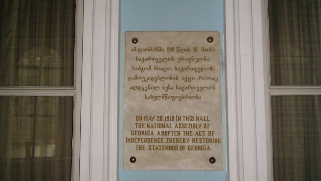 Мемориальная табличка: «26 мая 1918 года в этом зале Национальный совет Грузии принял декларацию о независимости, тем самым восстановив грузинскую государственность» 