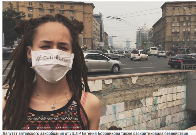 Девушка в защитном маске, на которой написано «Сибирь горит»