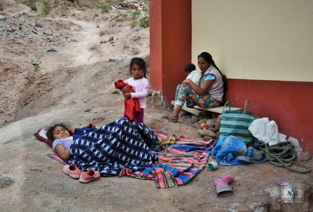 Женщина с детьми отдыхает в тени в жаркий полдень. Дети начинают помогать родителям на соляных террасах с 5 лет. Салинас-де-Марас, Перу