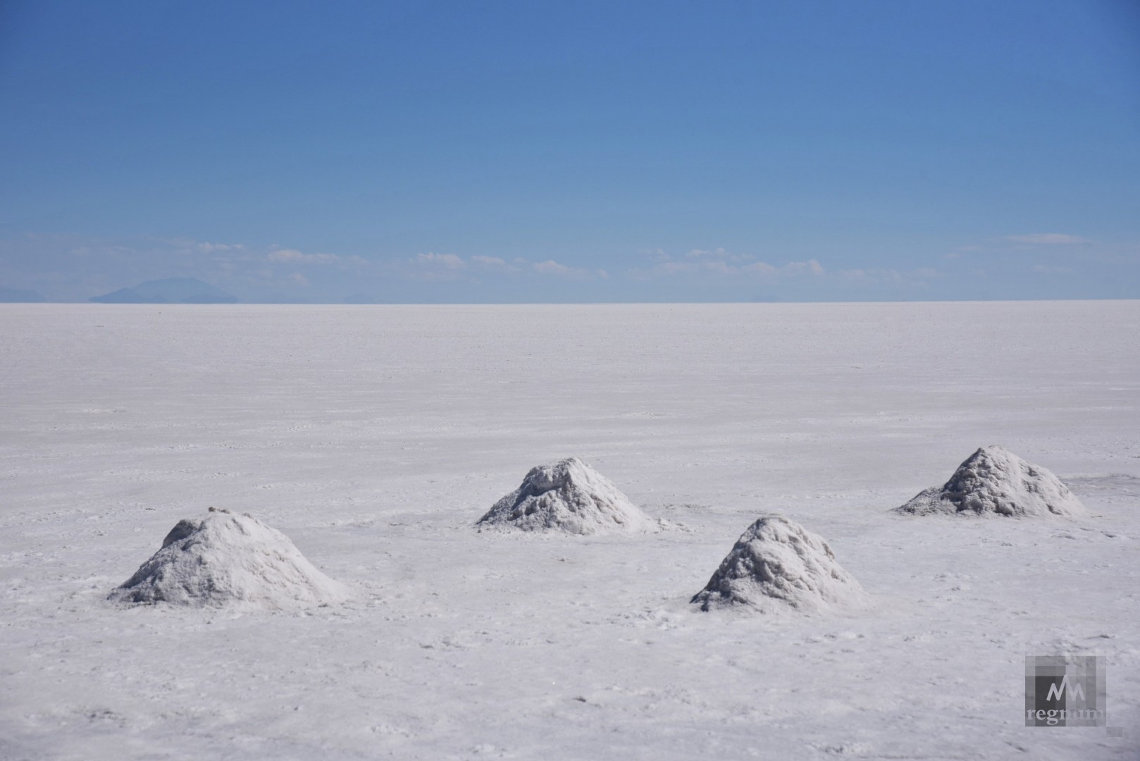 Верхний слой соли аккуратно снимается и укладывается в небольшие пирамиды, освобождая водяную поверхность, которая испаряется в течение недели, образуя новый соляной покров. Салар-де-Уюни, Боливия