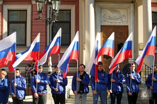 Волонтеры с российским флагом на Дне флага 