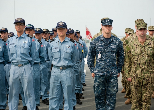 Солдаты военно-морских сил США и матросы японских сил самообороны строятся на японском десантном корабле Kunisaki