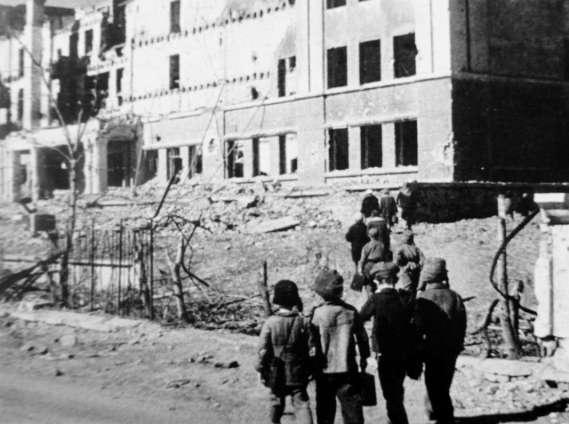 Дети идут на занятия в разрушенной начальной школе. 1943