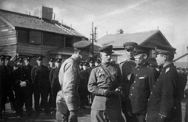 Советские офицеры и японские полицейские на улице города Сикука (в настоящее время город Поронайск в Сахалинской области) на Южном Сахалине. Август 1945 года
