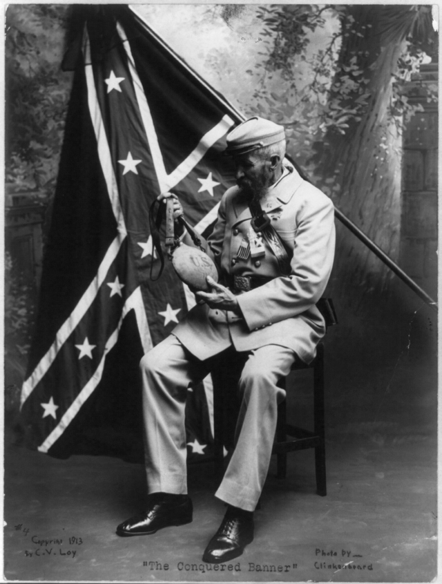 Пожилой солдат-южанин в серой пехотной униформе на фоне Боевого флага Конфедерации. На поясе пряжка с надписью «CSA», на груди памятная медаль «The Southern Cross of Honor». В руках трофейная фляжка северян. 1913