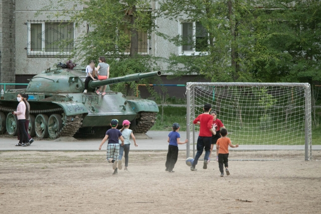 Дети играют в футбол во дворе дома 