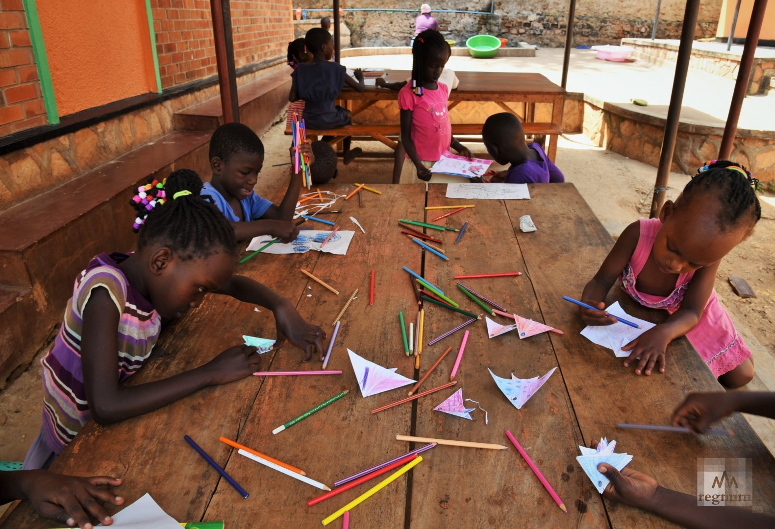 Дети во время художественных занятий. За этими же столами происходит прием пищи и выполнение домашнего задания после школы. Window of Life, Масинди, Уганда