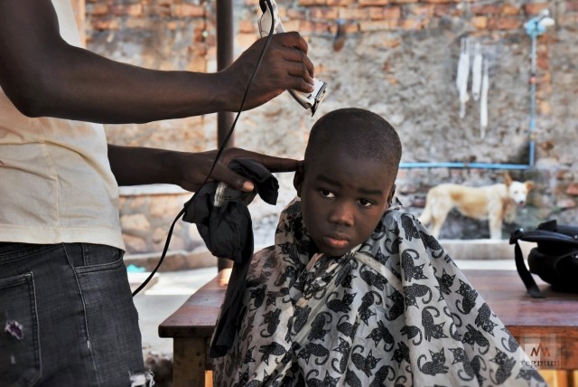 Джошуа (7 лет) во время бритья головы. Местный парикмахер приходит в приют раз в месяц, чтобы стричь детей. Window of Life, Масинди, Уганда