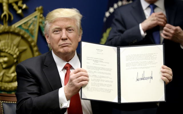 Дональд Трамп показывает подписанный указ по иммиграции