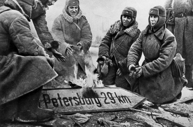 Бойцы РККА сжигают немецкий дорожный указатель. Ленинградская область, 1943