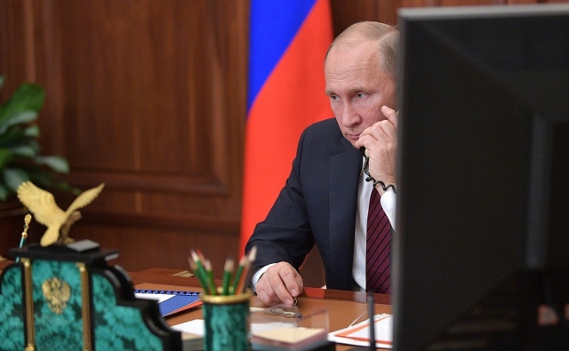 Владимир Путин говорит по телефону 