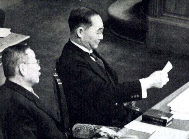 Ёнай читает докладную записку на пленарном заседании палаты представителей, сидя в кресле премьер-министра. 2 февраля 1940 года