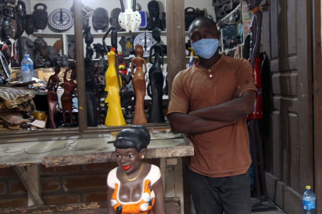 Скульптор у своего бутика в Центре ремесел де ла Виль д'Абиджан, Кот-д'Ивуар 