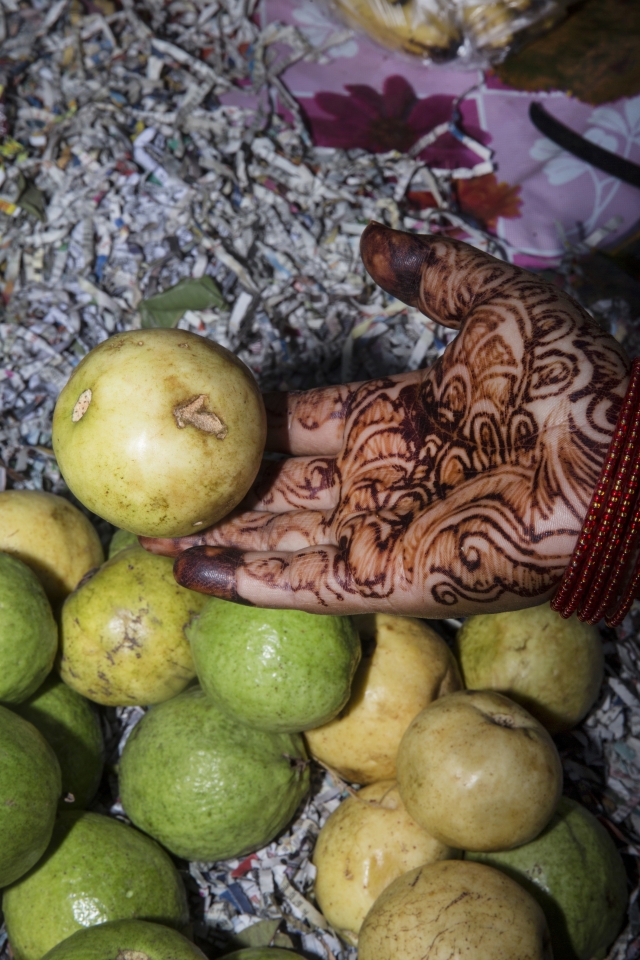 Рука продавщицы фруктов, украшенная мехенди (традиционный узор хной)