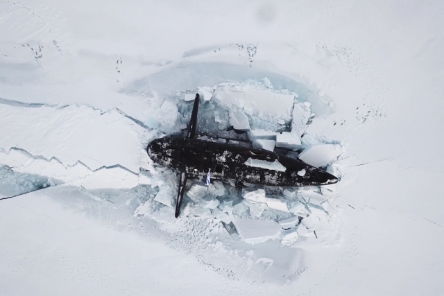 Российская атомная ракетная подводная лодка всплывает из-подо льда в Арктике 
