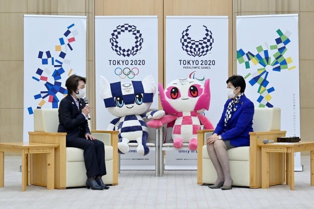 Губернатор Токио Юрико Коикэ на фоне талисманов Мирайтова и Сомэйти 