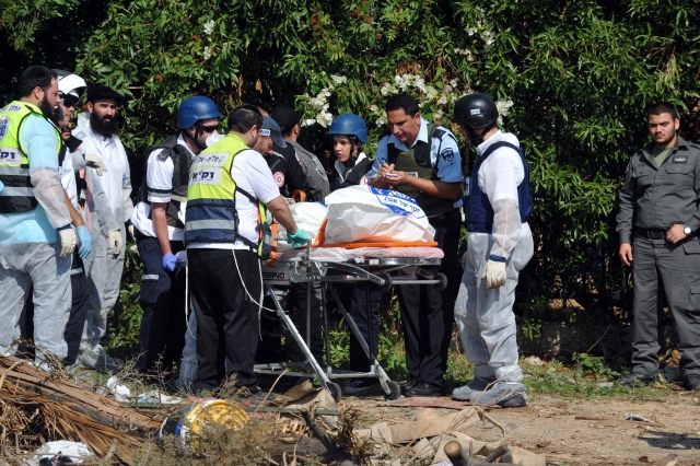 Израильские спасатели эвакуируют одну из трех жертв, пострадавших от попадания ракеты ХАМАС