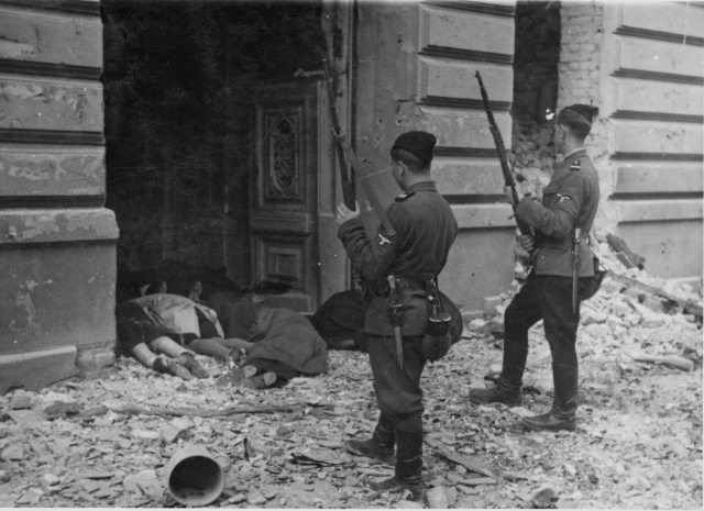 Двое «хиви» над телами убитых евреев Варшавского гетто. 1943