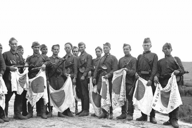 Советские солдаты держат флаги поверженной Японии