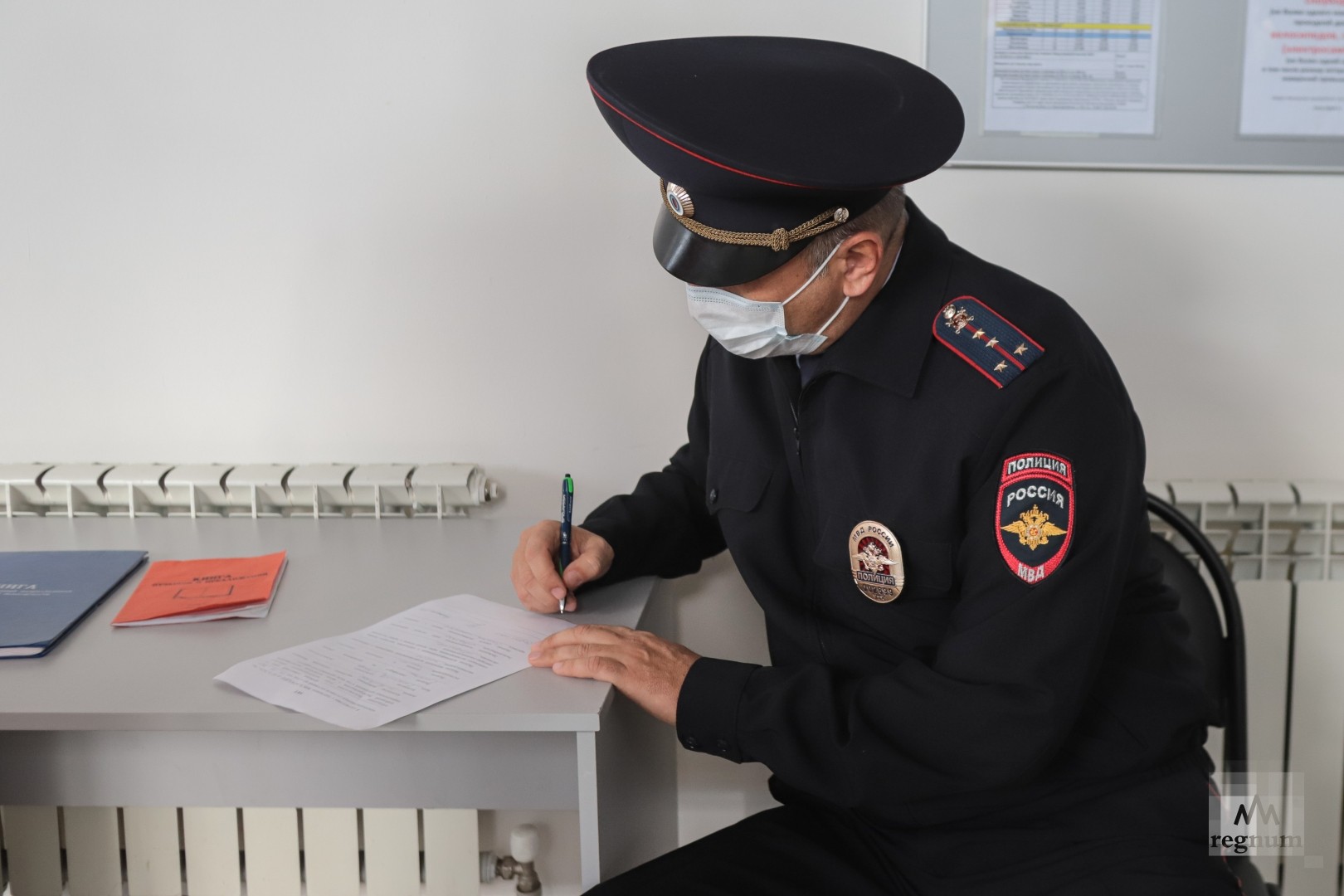 Сотрудник полиции составляет протокол о нарушении масочного режима