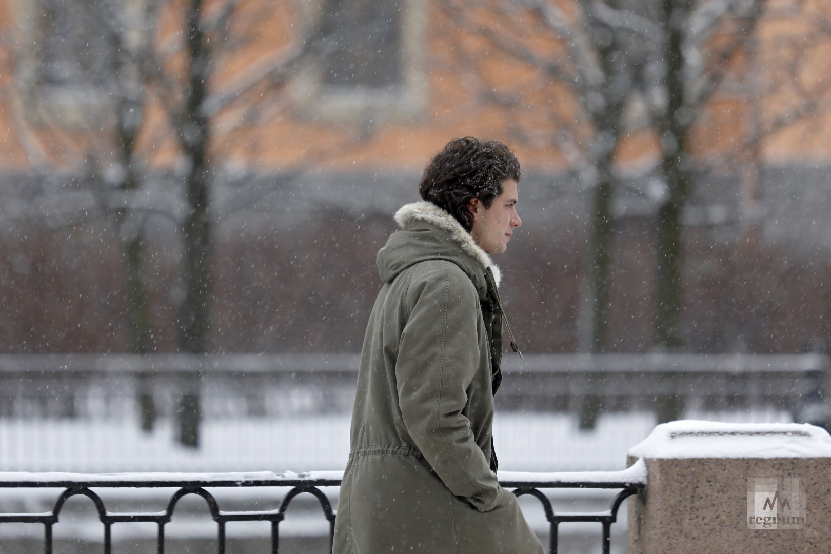 Молодой человек во время снегопада в Санкт-Петербурге 