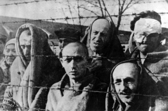 Узники концлагеря Освенцим у колючей проволоки