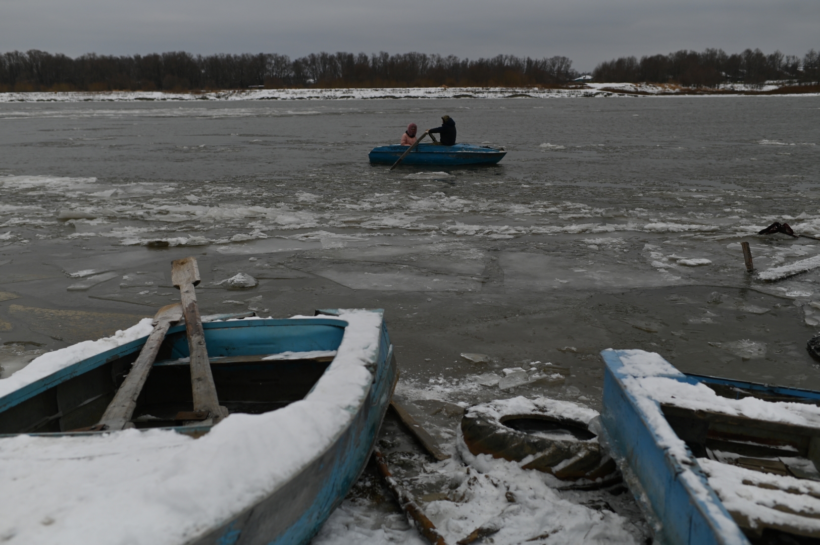 Сергей Волков и жена его брата Анна плывут через Иртыш за продуктами во время осеннего ледостава