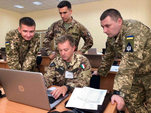 Два офицера итальянской армии наставничают над офицерами украинской армии 