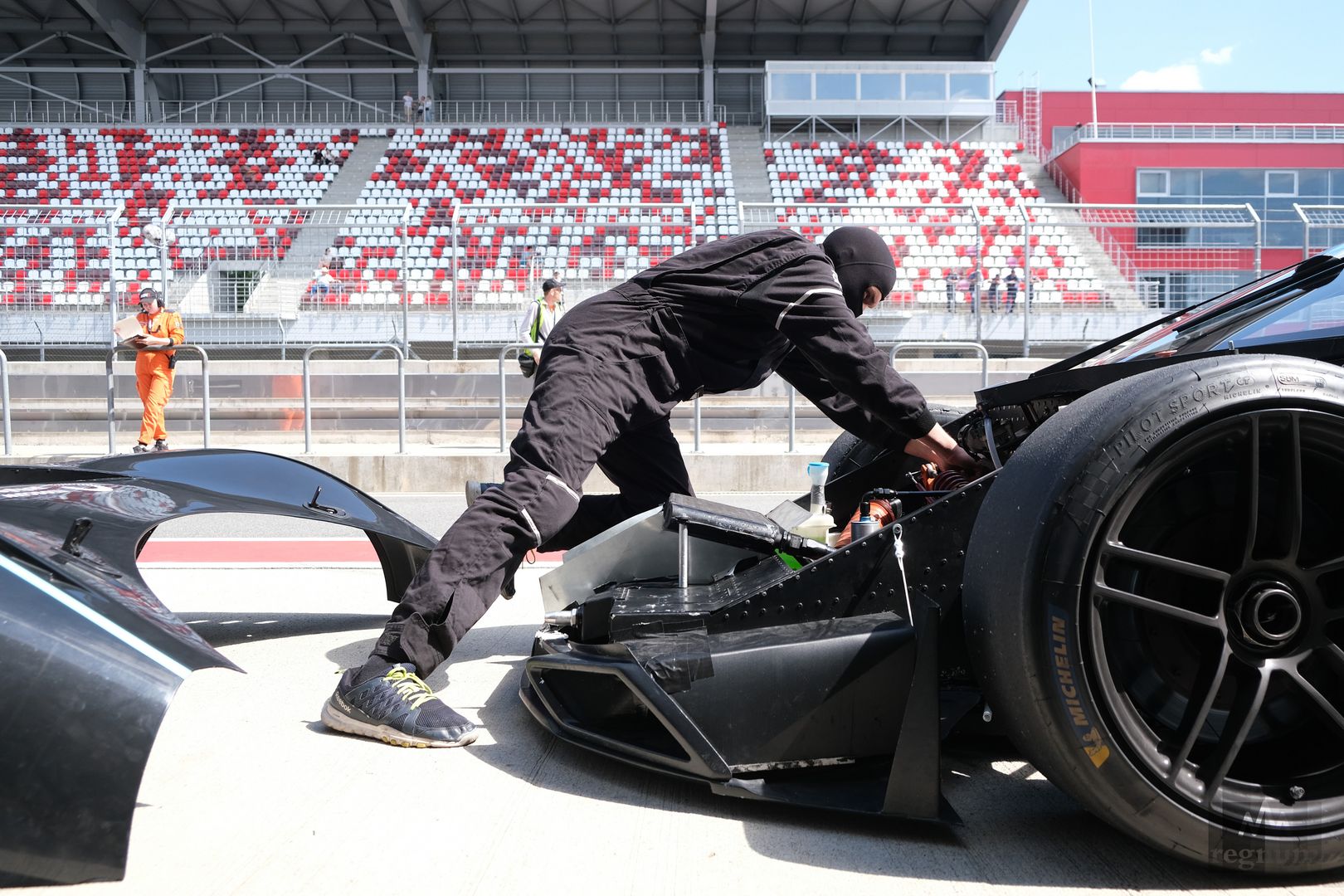 Механик осматривает гоночный спорткар Marussia GT на трассе гонки на выносливость Russian Endurance Challenge