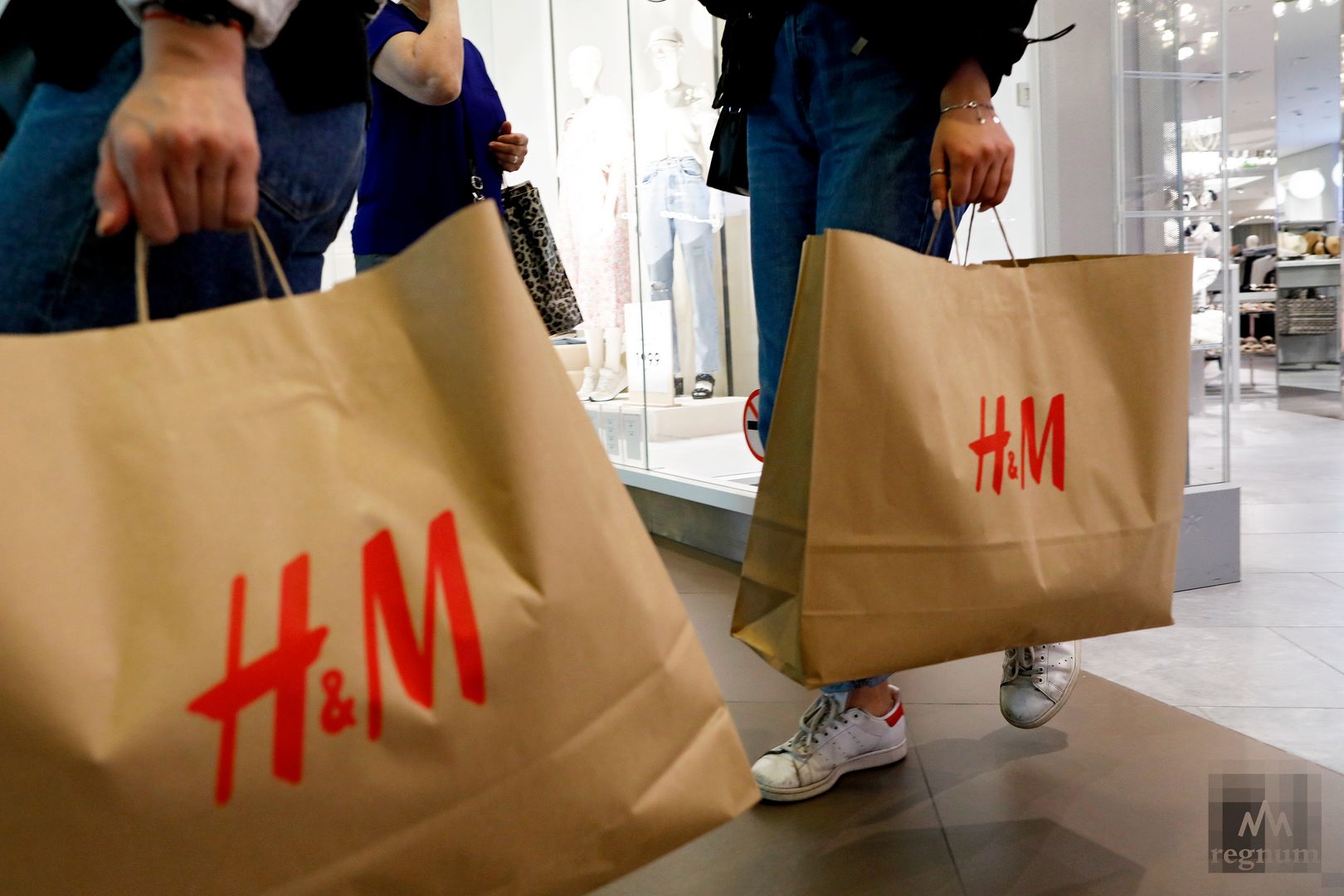 Покупатели с пакетами с товарами из магазина H&M, временно возобновившего работу