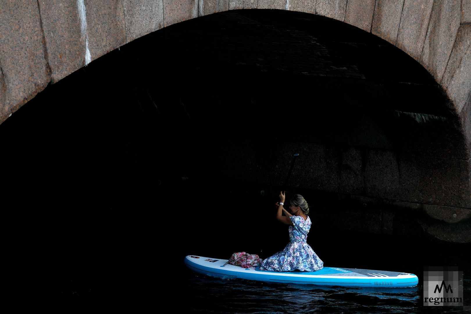 Участница фестиваля SUP-серфинга «Фонтанка-SUP — 2022» плывет по реке Фонтанка