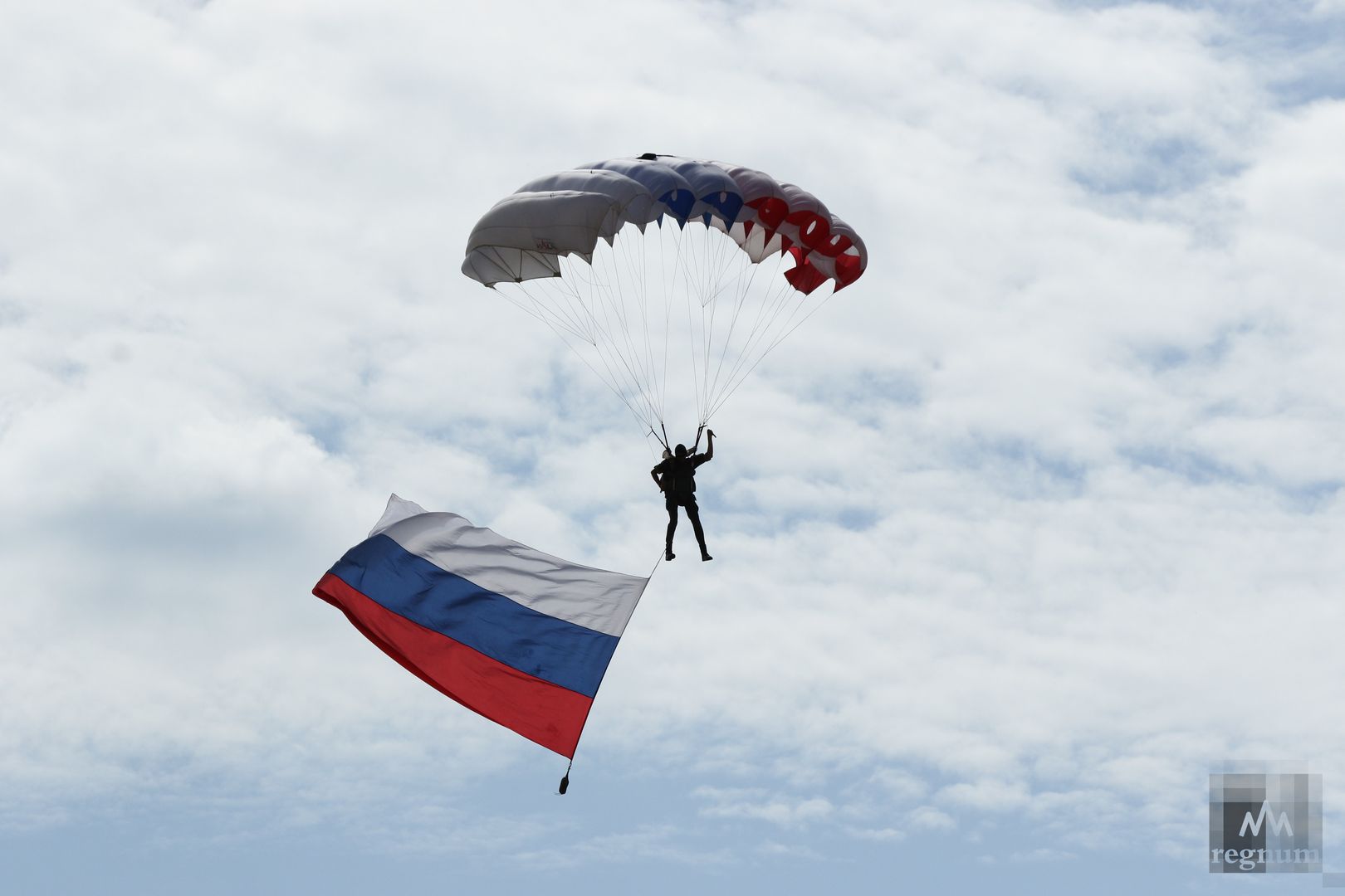 Парашютист с флагом России спускается на полигон Алабино