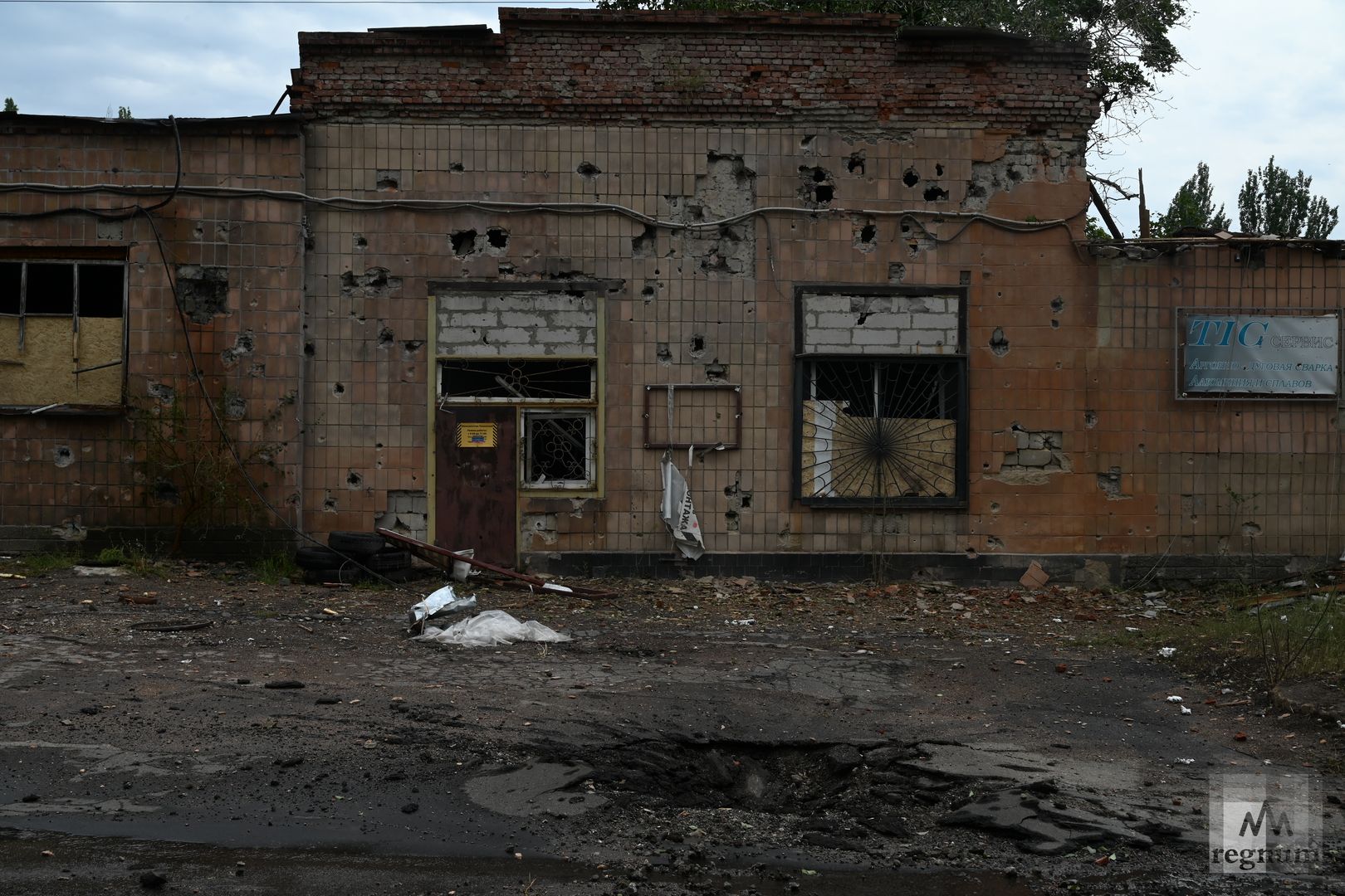 Воронка от снаряда у здания сервиса. Донецк, 16 августа 2022 г.