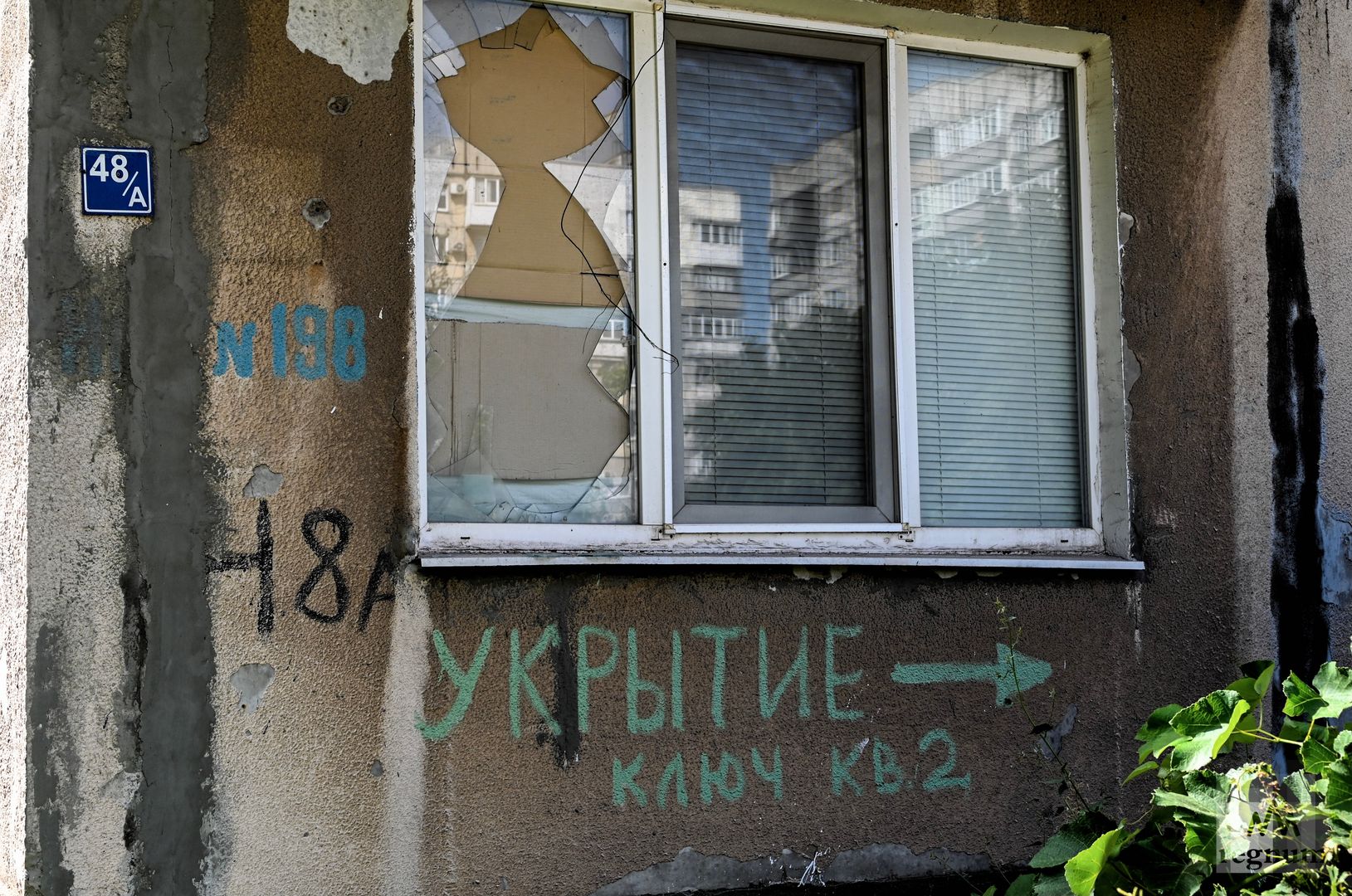 Заколоченные фанерой окна в Мариуполе