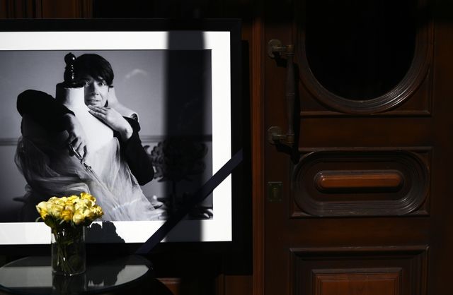 Цветы и портрет модельера возле дверей в Дом моды Валентина Юдашкина в Вознесенском переулке в Москве